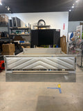 King bed frame with white chevron upholstered footboard and mirrored trim – front view