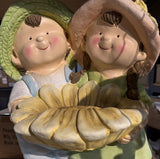 Boy and girl holding sunflower birdbath garden statue – close-up