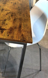 White molded plastic dining chair with chrome-finish metal legs beside the table