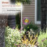 Alpine 47 inch triple daisy wind spinner garden stake – spinning blades in a garden bed