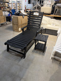 Black chaise lounge chair with matching black two-tier side table, front view – real store photo