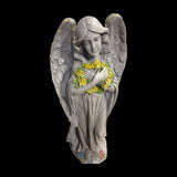 Alpine solar LED angel statue holding a yellow rose wreath – real photo showing the LED string lights on the wings
